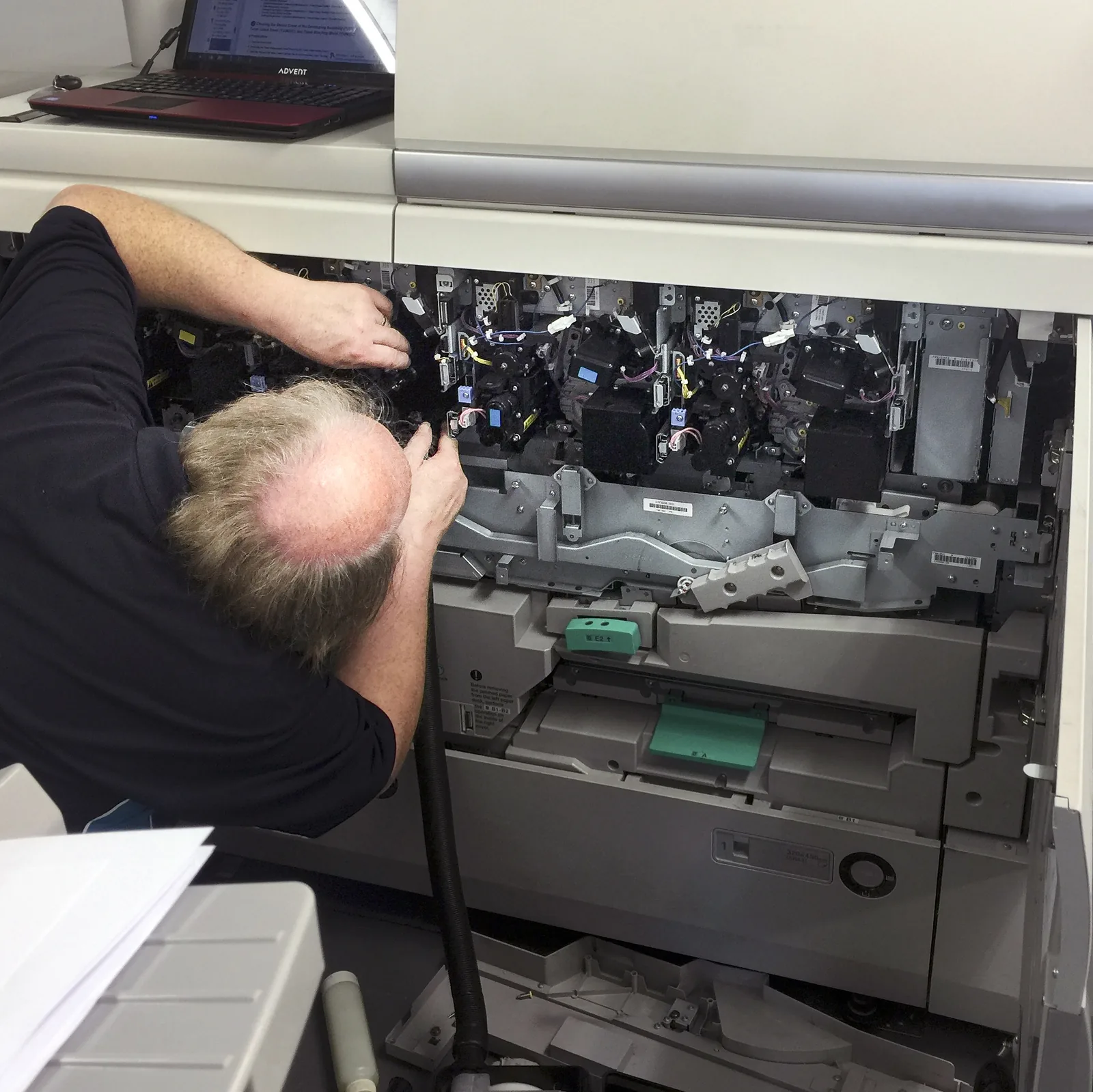 HAD-COPY engineer carrying out hands-on service work inside a professional print device